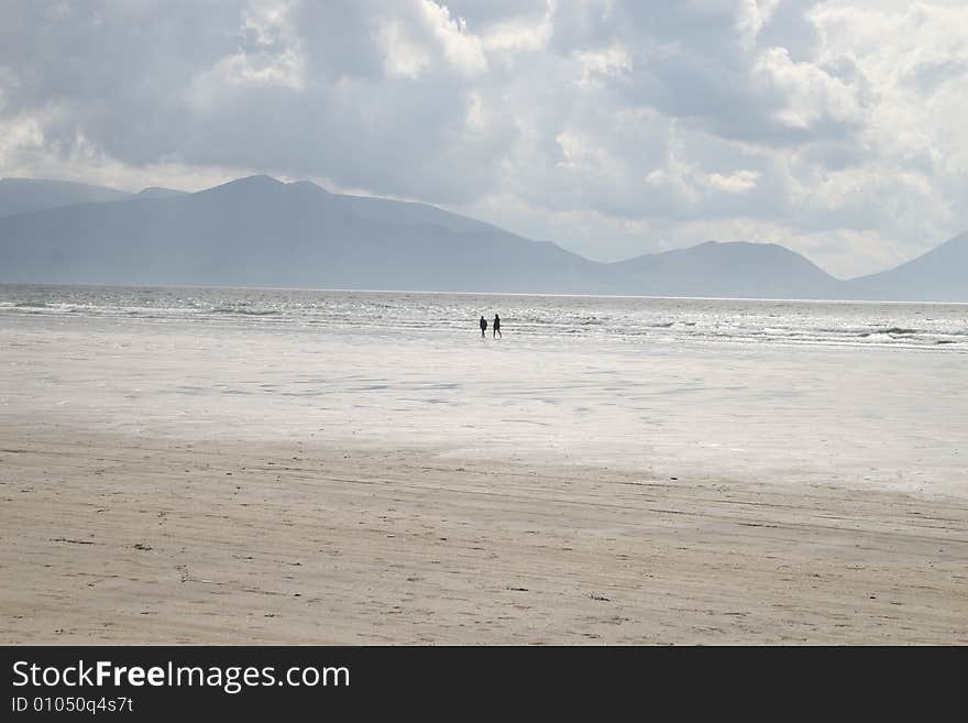 Two people walking on a beach. Two people walking on a beach