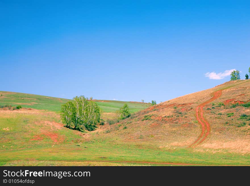 Green field under blue sky with clouds