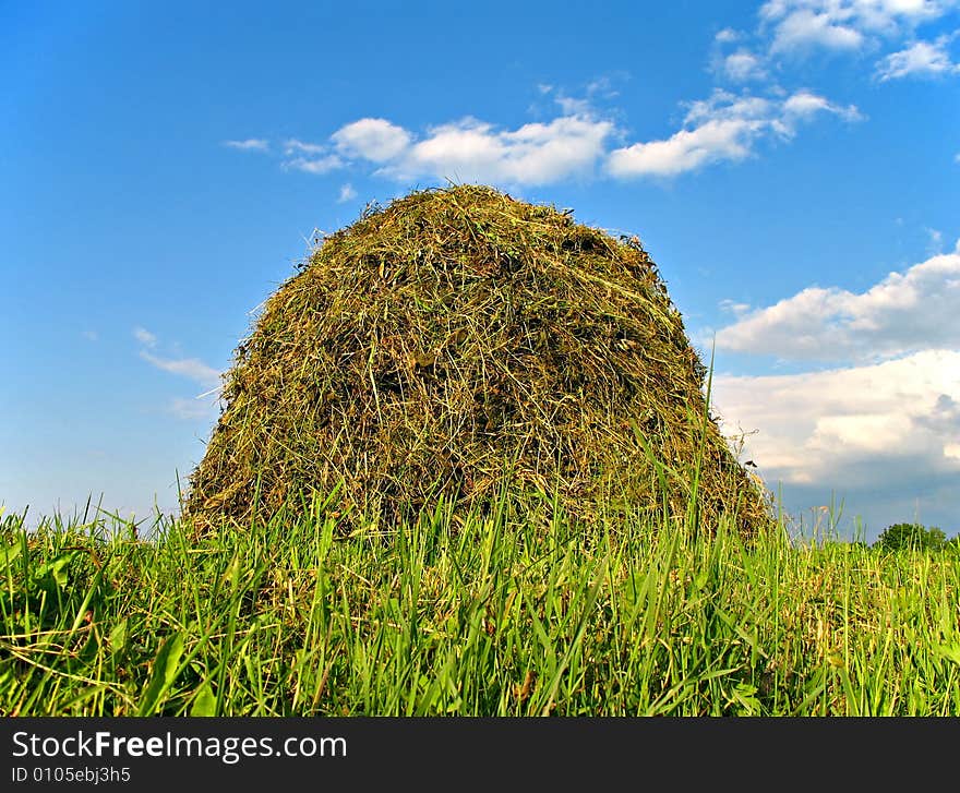 Photo of stacked hay and clouds