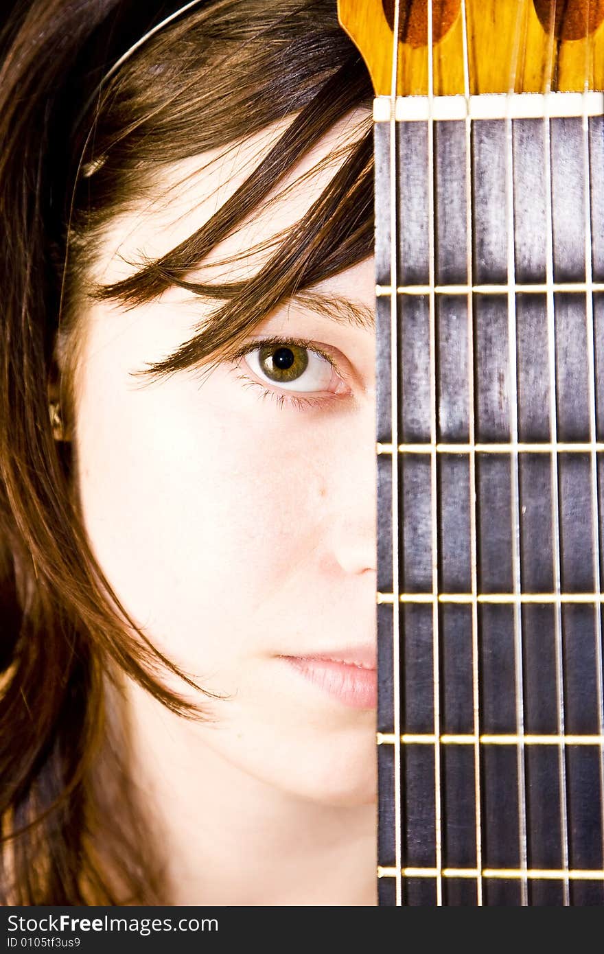 Young beautiful woman behind guitar fretboard. Young beautiful woman behind guitar fretboard