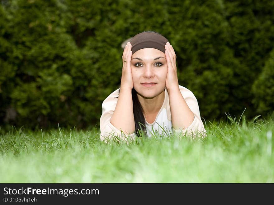 Attractive brunette woman lying on grass. Attractive brunette woman lying on grass