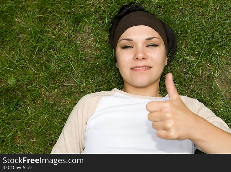 Attractive brunette woman lying on grass. Attractive brunette woman lying on grass