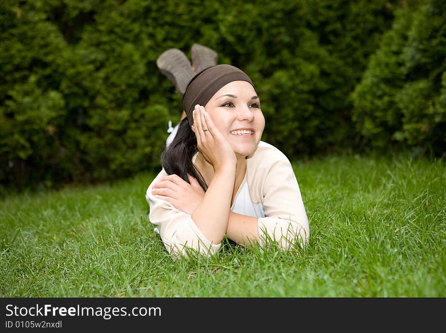 Attractive brunette woman lying on grass. Attractive brunette woman lying on grass