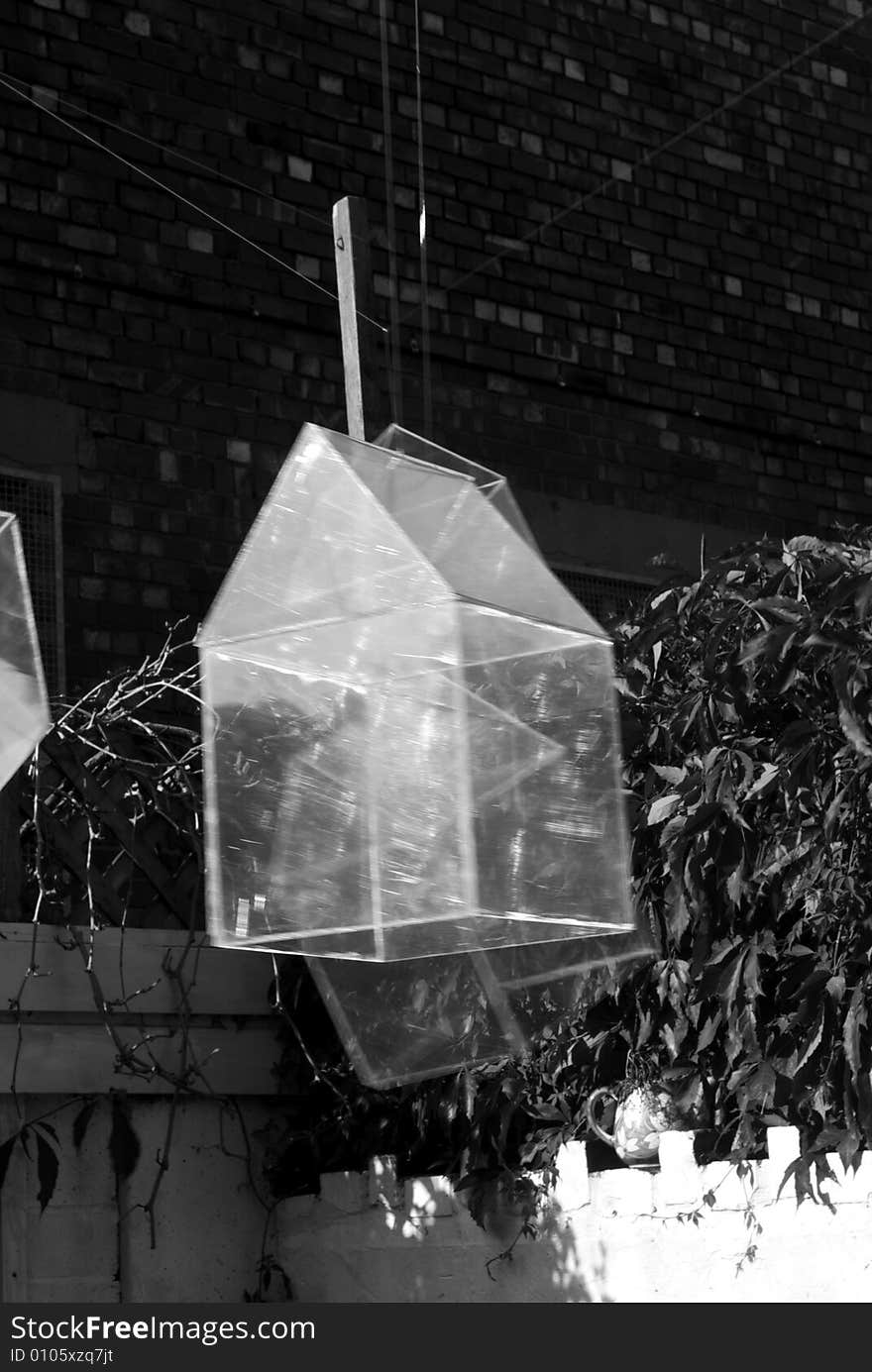 Installation art piece with floating perspex houses suspended on wire to look like polygonal soap bubbles, close up in black and white. Installation art piece with floating perspex houses suspended on wire to look like polygonal soap bubbles, close up in black and white