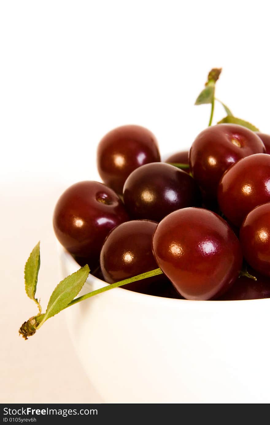 Bowl with ripe juicy cherries on a white background. Bowl with ripe juicy cherries on a white background