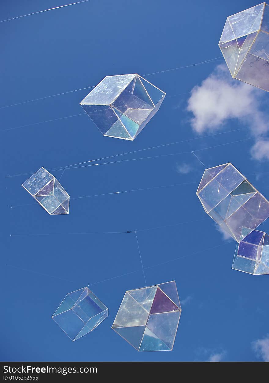 Installation art piece with floating perspex houses suspended on wire to look like polygonal soap bubbles, against vivid blue sky. Installation art piece with floating perspex houses suspended on wire to look like polygonal soap bubbles, against vivid blue sky