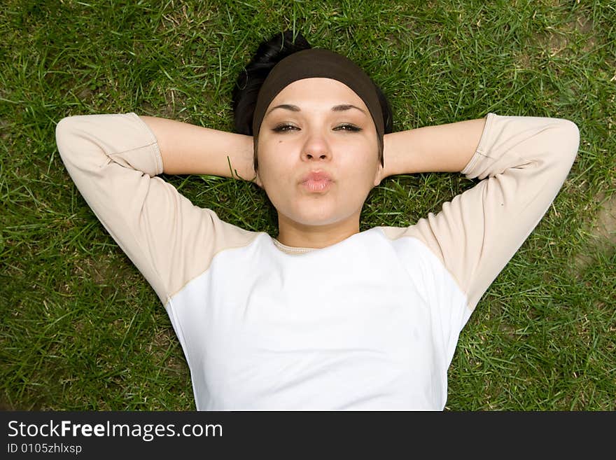 Attractive brunette woman lying on grass. Attractive brunette woman lying on grass