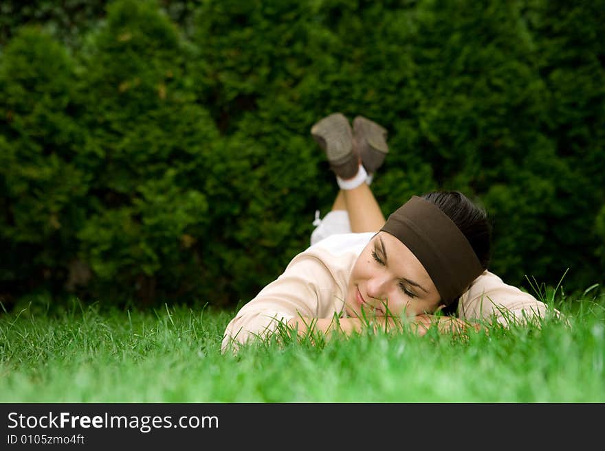 Attractive brunette woman lying on grass. Attractive brunette woman lying on grass