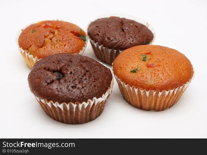 Four different flavor muffins put together on white background.