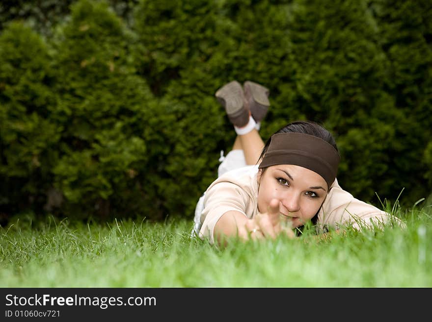 Attractive brunette woman lying on grass. Attractive brunette woman lying on grass