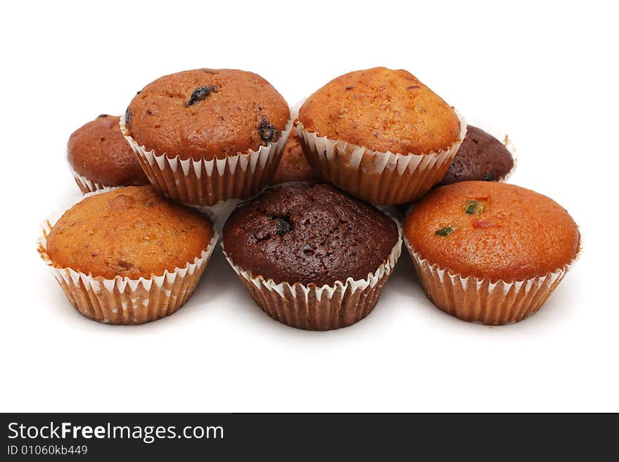 Many muffins stacked together on white background.