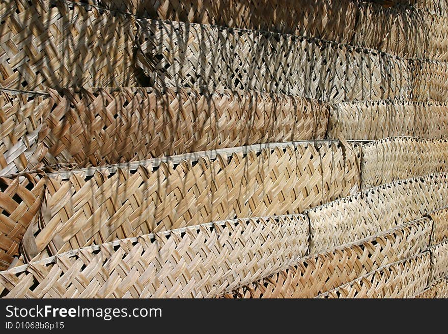 A photo good for backgrounds showing the thatched wall of a hut.