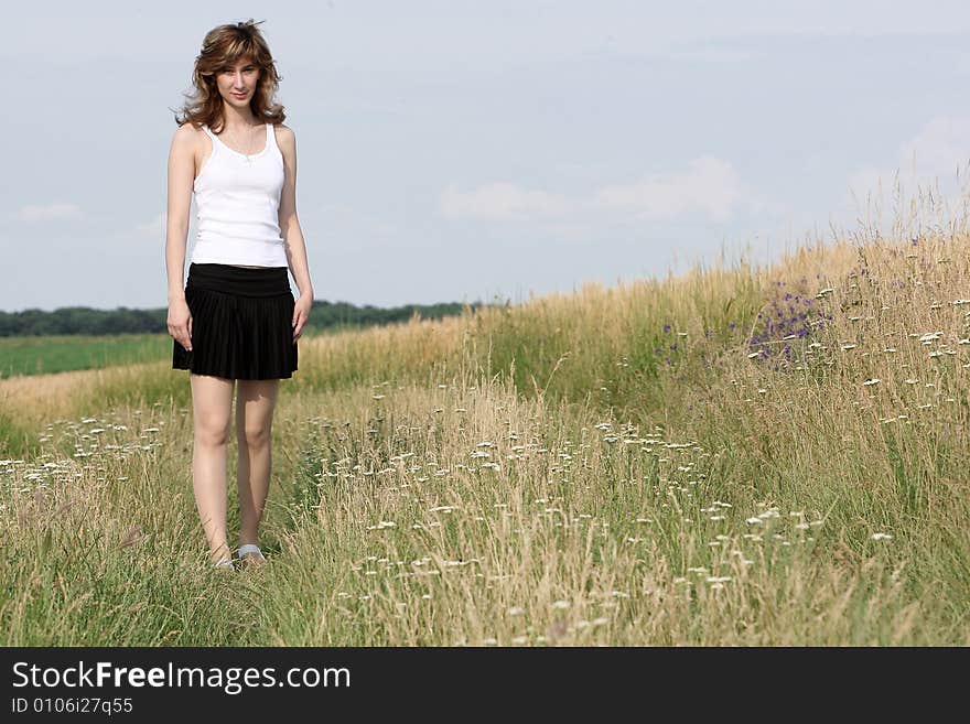 A beautiful girl running on the field. A beautiful girl running on the field