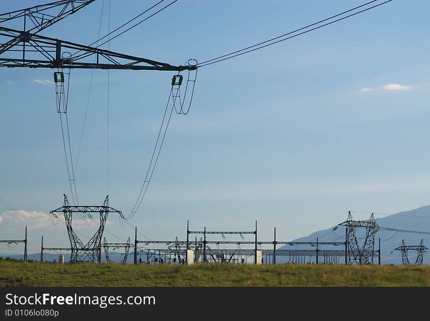 Electrical high voltage power lines, isolators and mast in blue cloudy sky, horizontal. Electrical high voltage power lines, isolators and mast in blue cloudy sky, horizontal.