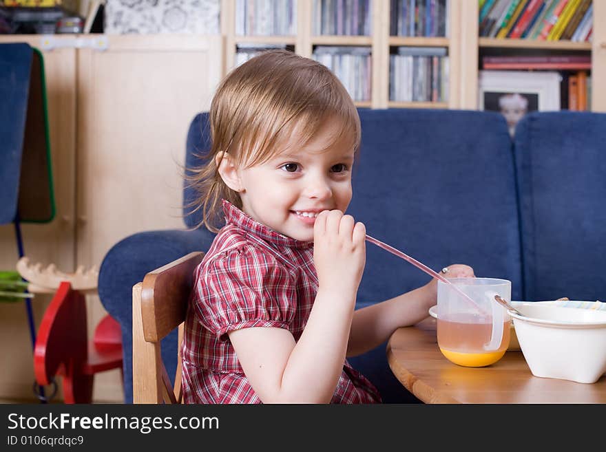 Little girl drinking fresh orange juice