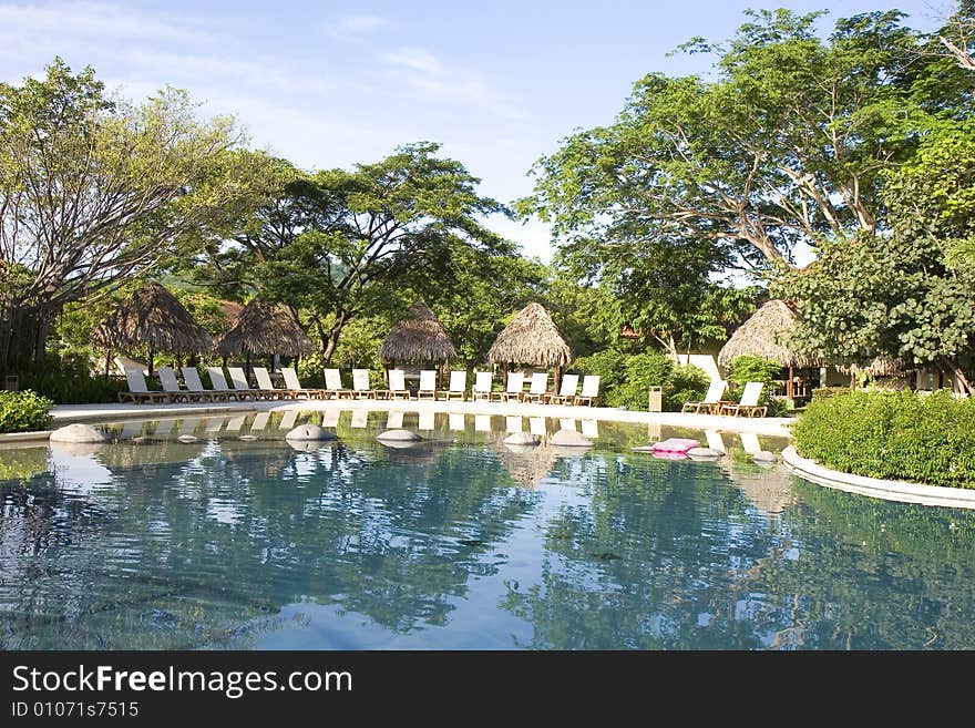 A beautiful resort swimming pool with lounge chairs. A beautiful resort swimming pool with lounge chairs