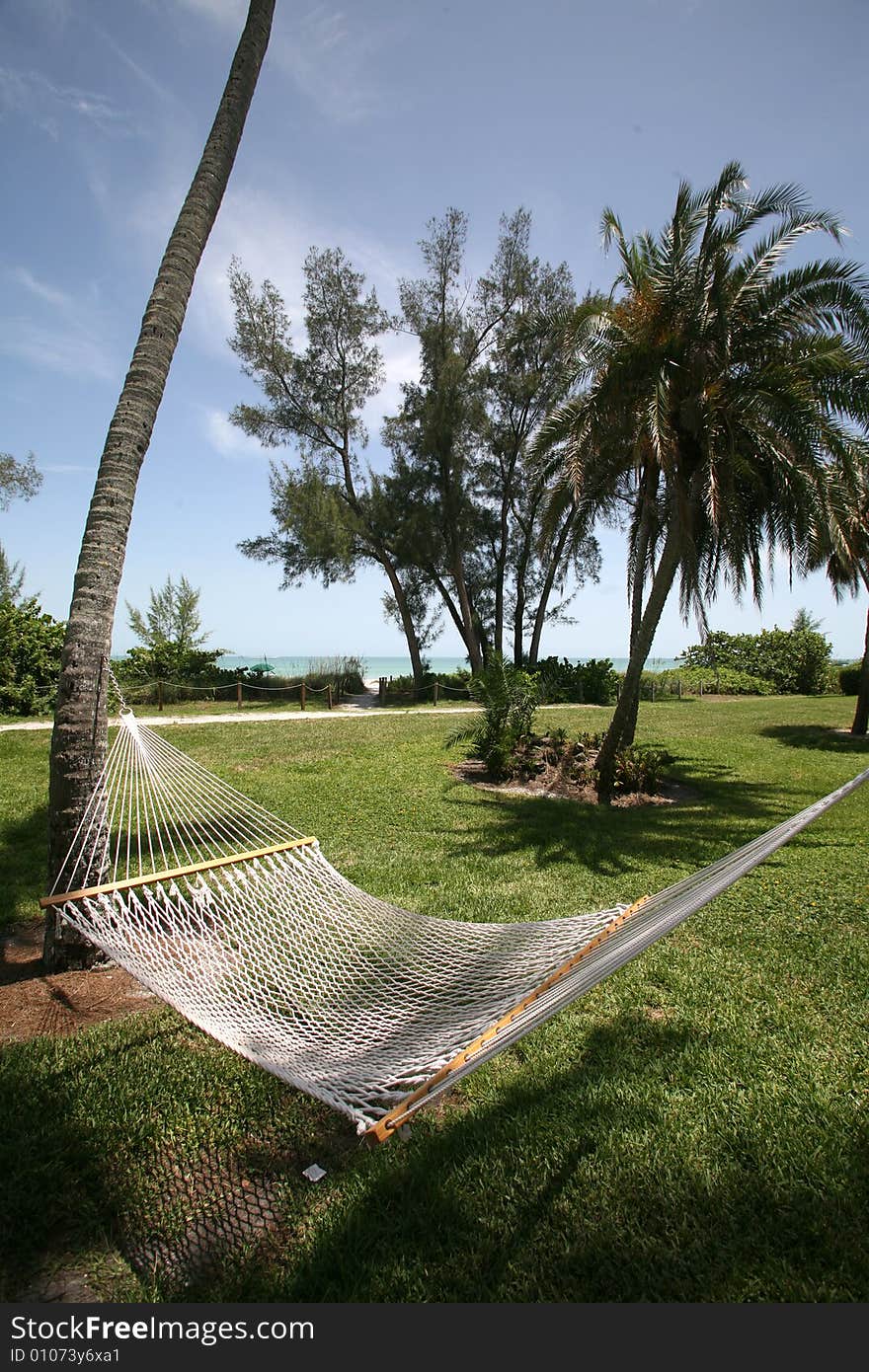 A photo taken of a hammock between two palm trees with the ocean in the background. Photo taken on Sanibel / Captiva Island. A photo taken of a hammock between two palm trees with the ocean in the background. Photo taken on Sanibel / Captiva Island.