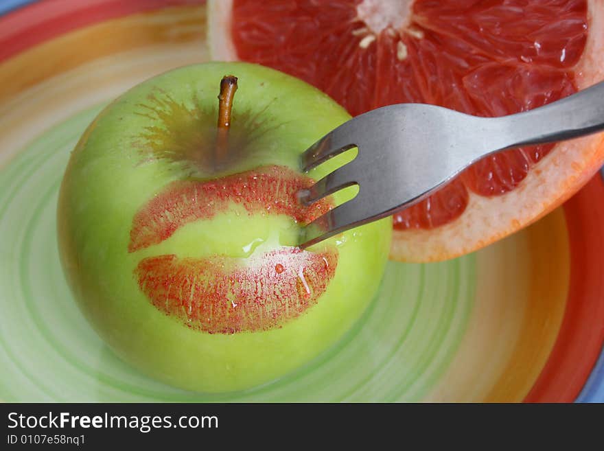 Sliced Pomelo and a whole apple with red lips. Sliced Pomelo and a whole apple with red lips