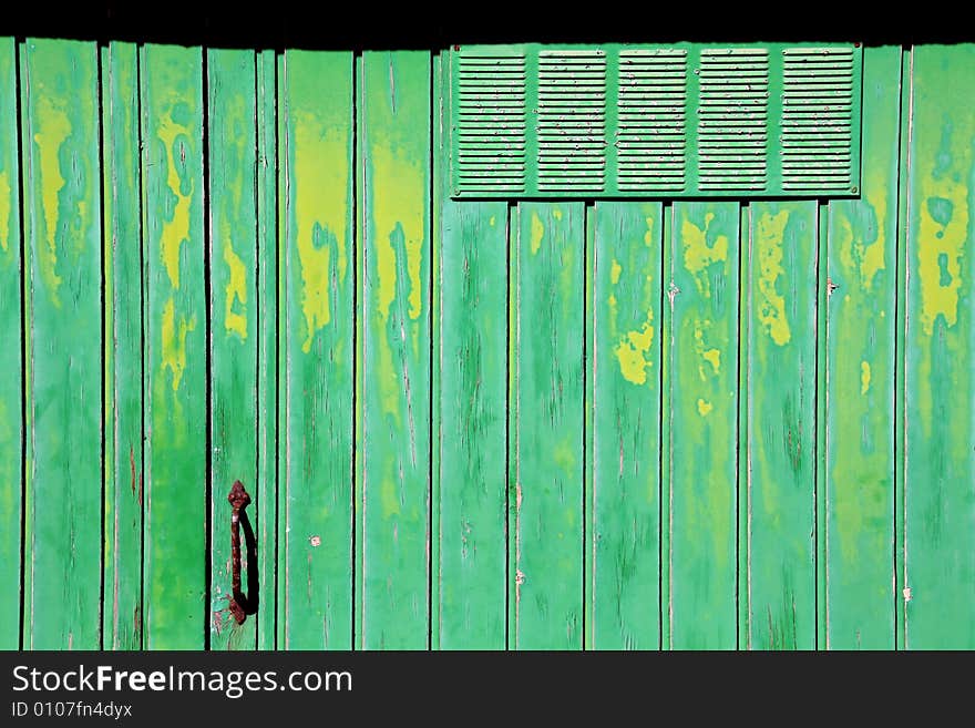 Old green and yellow garage door, crusty and rusty. Old green and yellow garage door, crusty and rusty