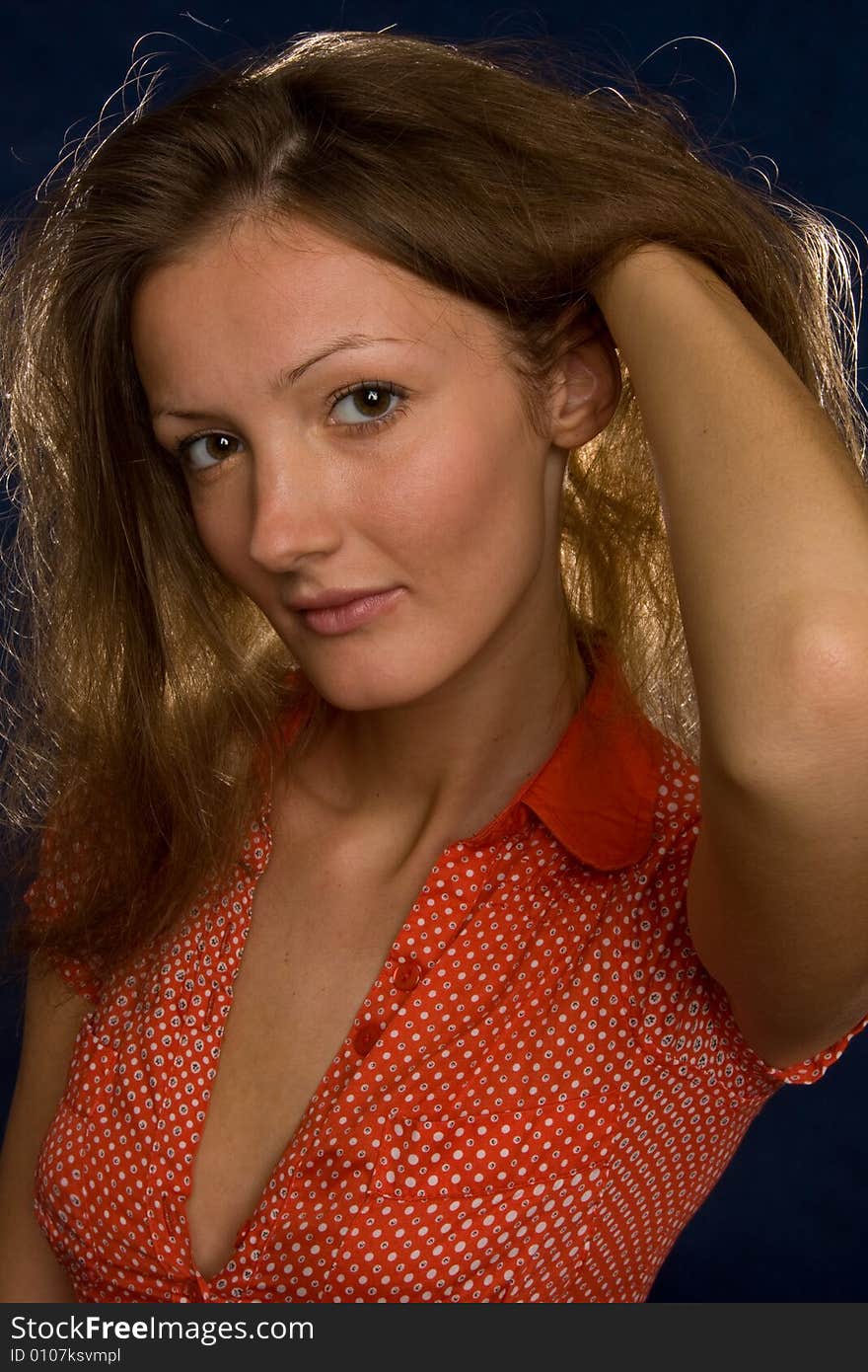 A portrait of a beautiful young woman playing with her reddish hair