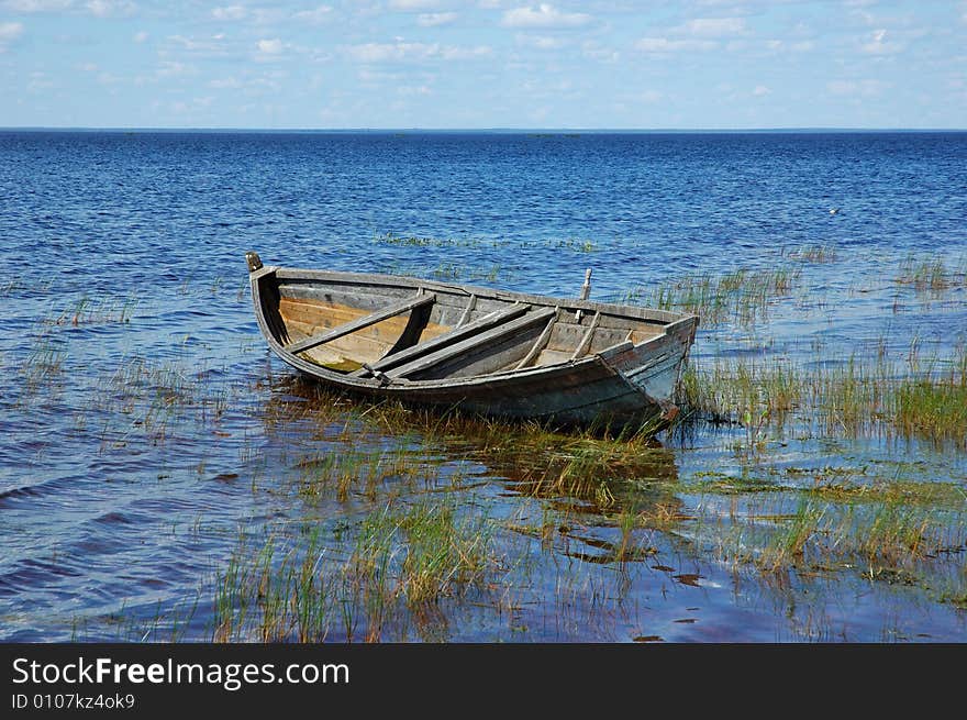 Old wooden fishing boat near the lake bank, north Russia. Old wooden fishing boat near the lake bank, north Russia