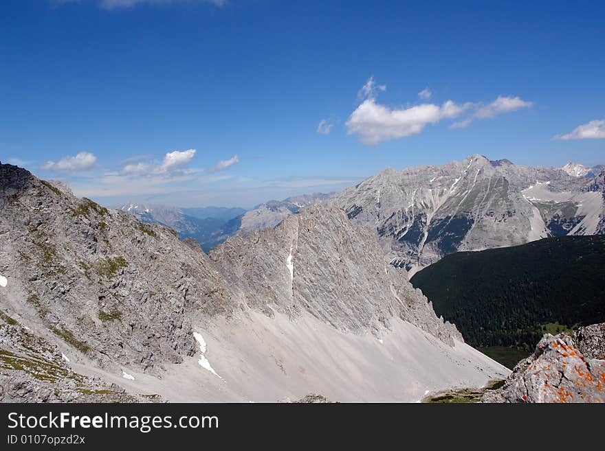 Clouds above the mountains Austrian  Alpes . The snow on the rocks. Sight from the peak of Hafelkarspitze mountain .Not so far from Innsbruck  . Clouds above the mountains Austrian  Alpes . The snow on the rocks. Sight from the peak of Hafelkarspitze mountain .Not so far from Innsbruck  .