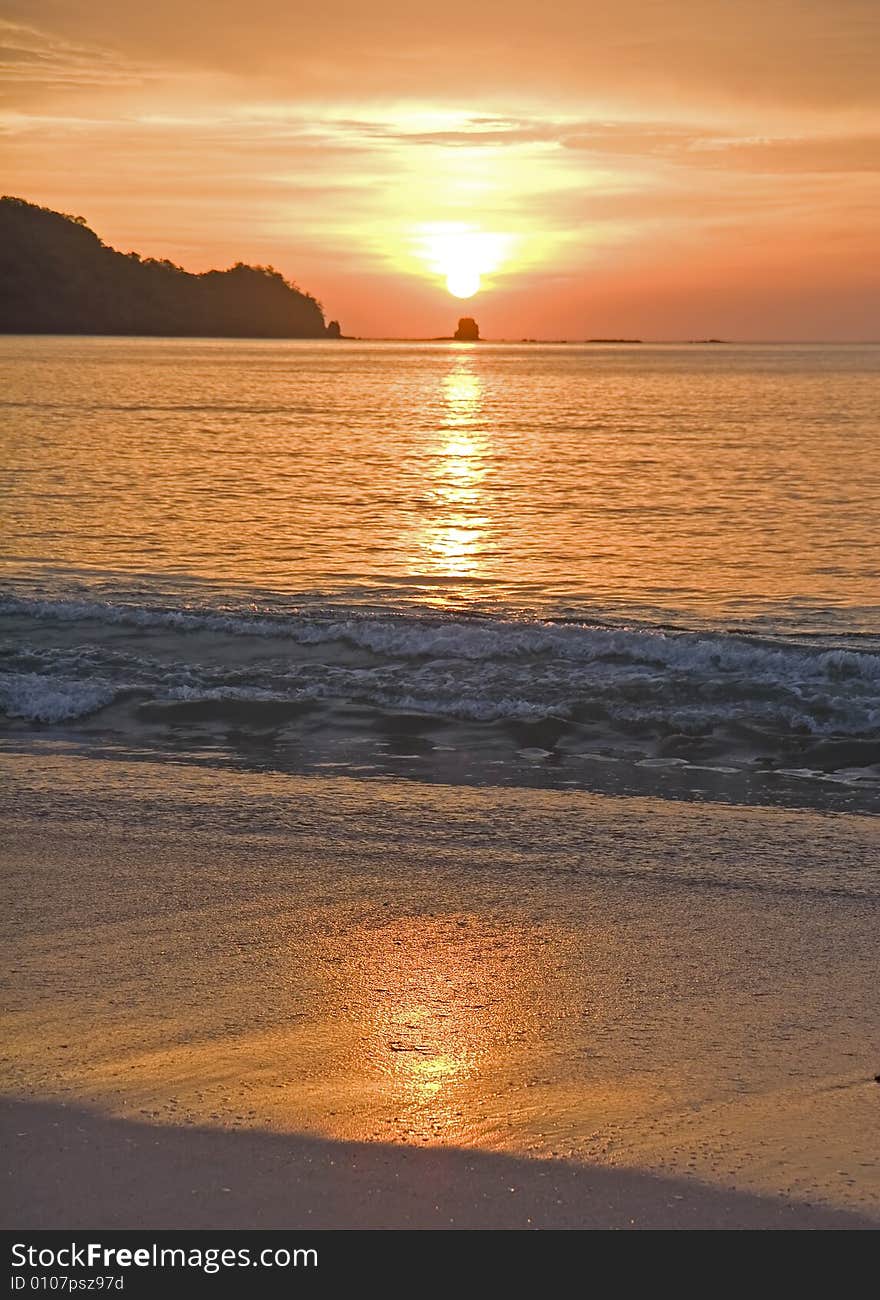 A beautiful orange sunset reflected in the wet sand. A beautiful orange sunset reflected in the wet sand