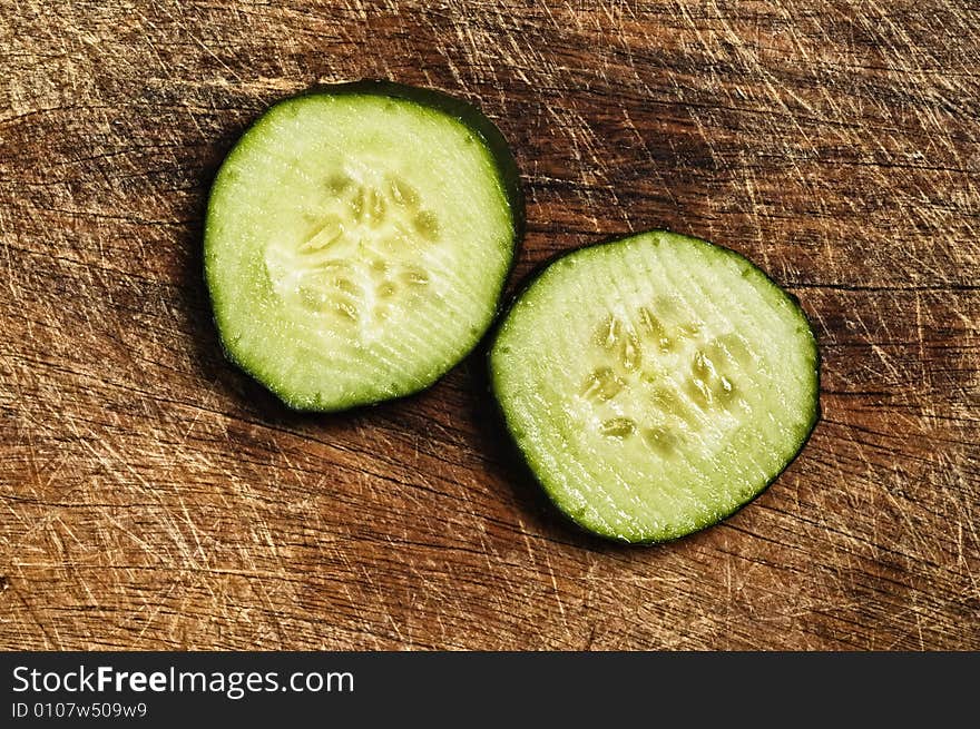 Slices of cfresh ucumber on a wooden background.