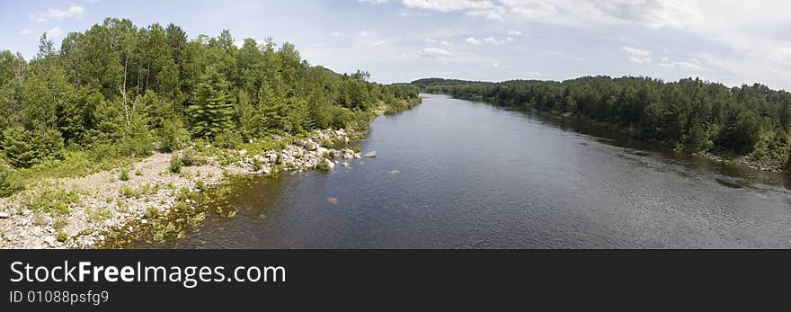 Panoramic view of a river surrounded by forests. Panoramic view of a river surrounded by forests