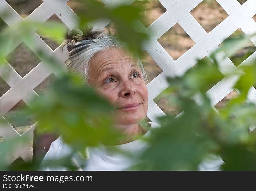 Portrait of attractive mature woman sitting in garden. Portrait of attractive mature woman sitting in garden.