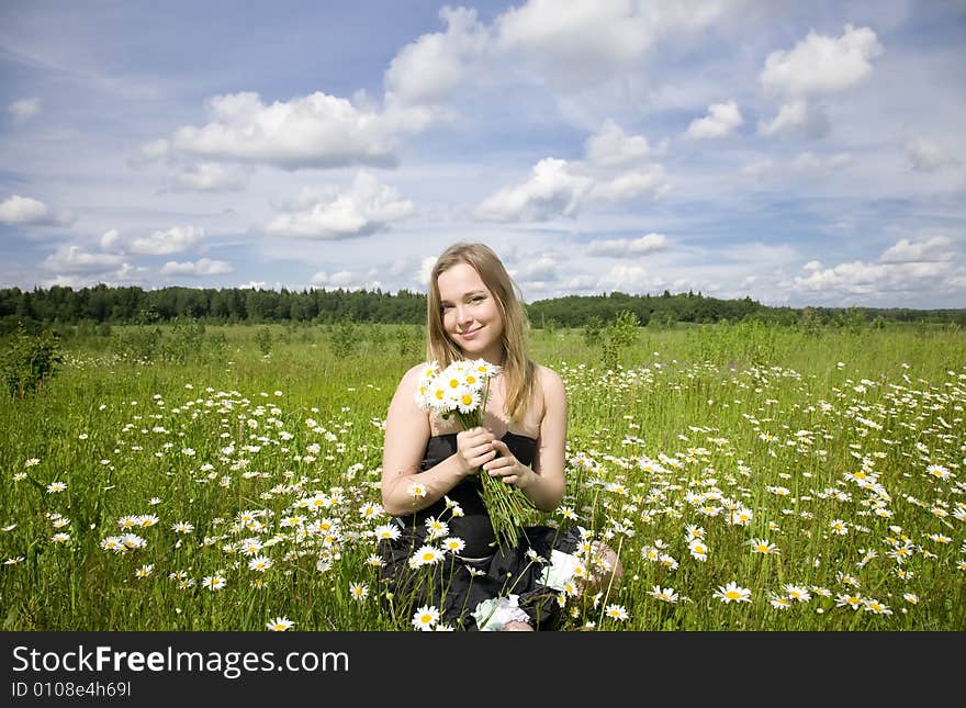 Woman With Flowers On The Meadow. Woman With Flowers On The Meadow