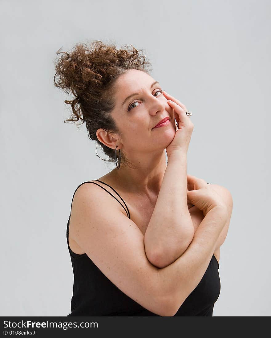 Serene woman with hand in face supporting her head and her hair up, isolated