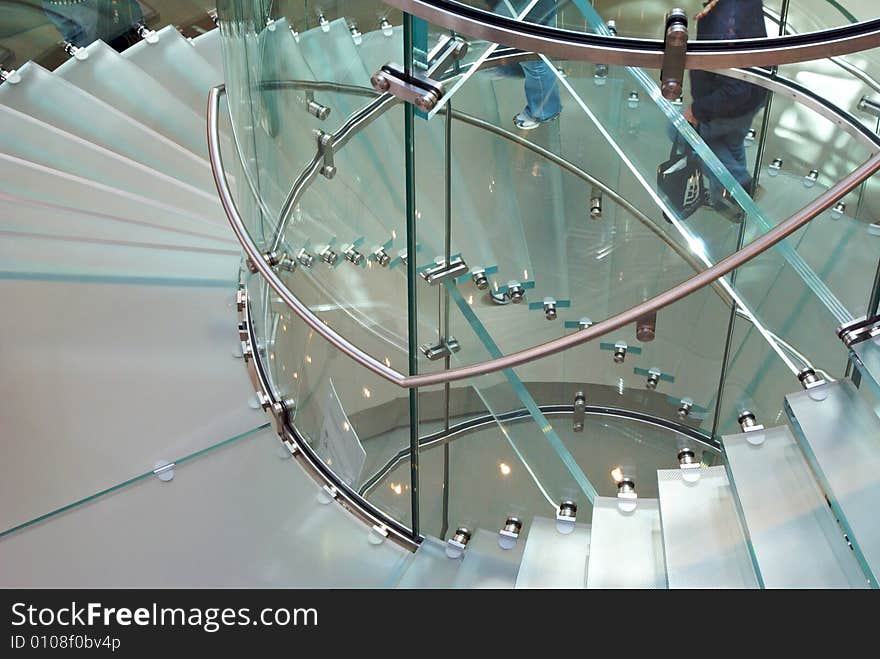 Looking down through a transparent staircase that spirals around. Looking down through a transparent staircase that spirals around