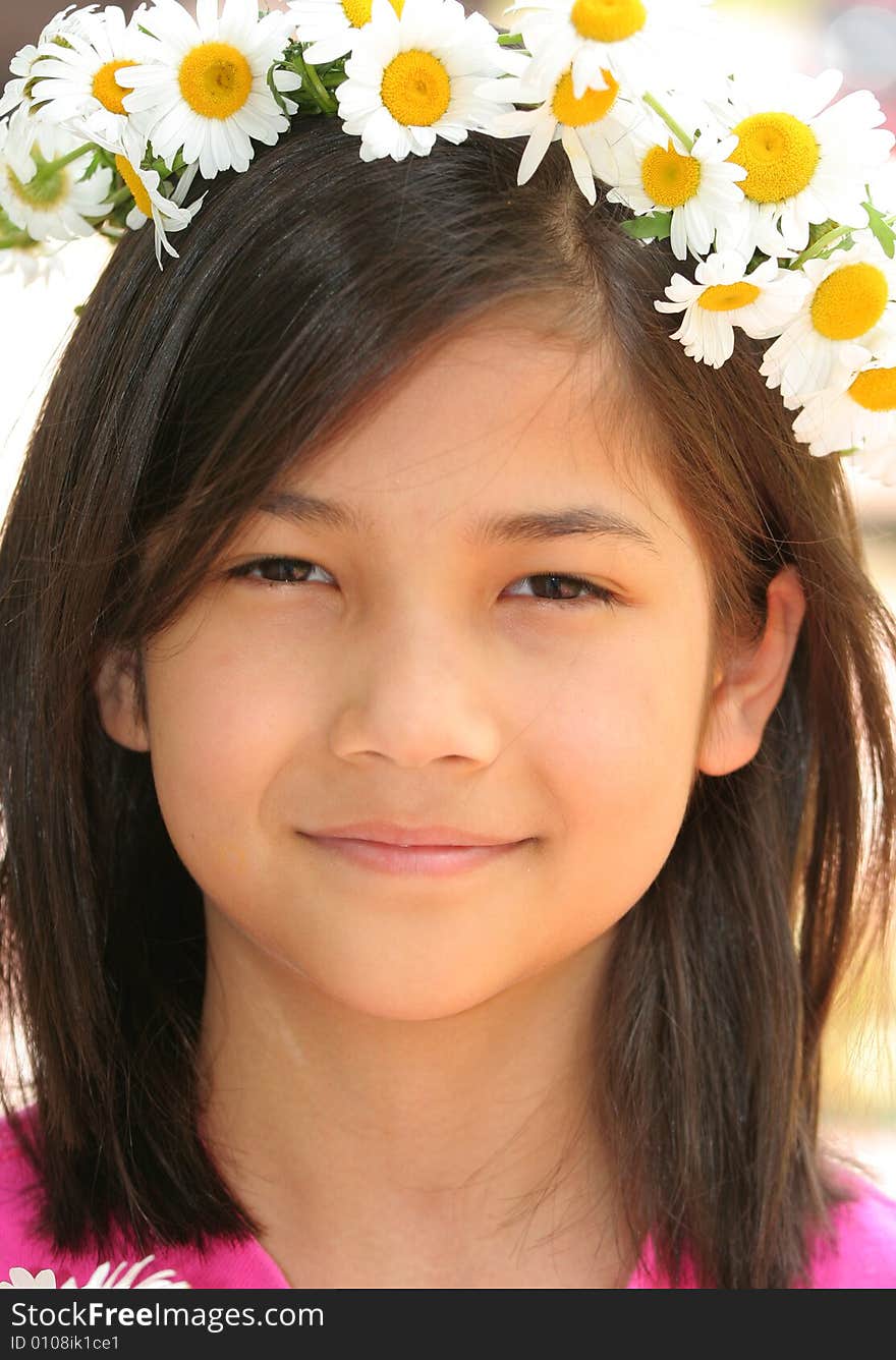 Little girl with crown of daisies on head