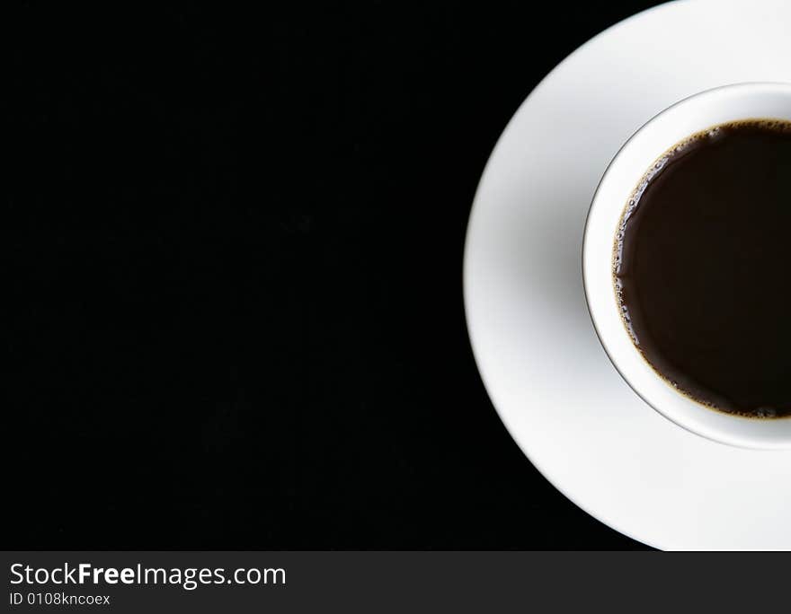 Partial top view of a cup of coffee on a saucer.