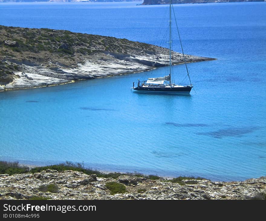 Large sailboat sitting in a cove of Poliegos Island. Large sailboat sitting in a cove of Poliegos Island.