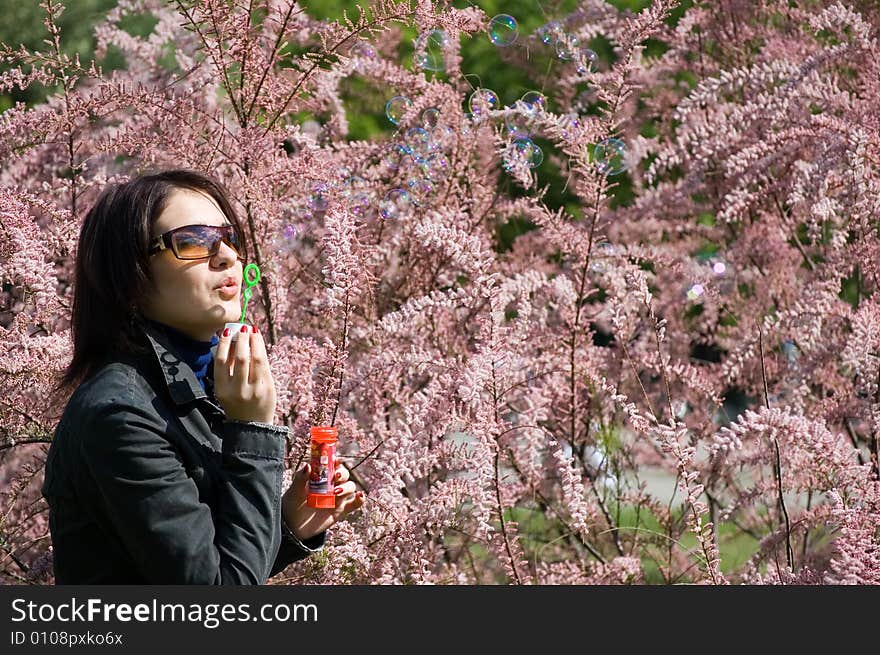 Girl blowing bubble in the park