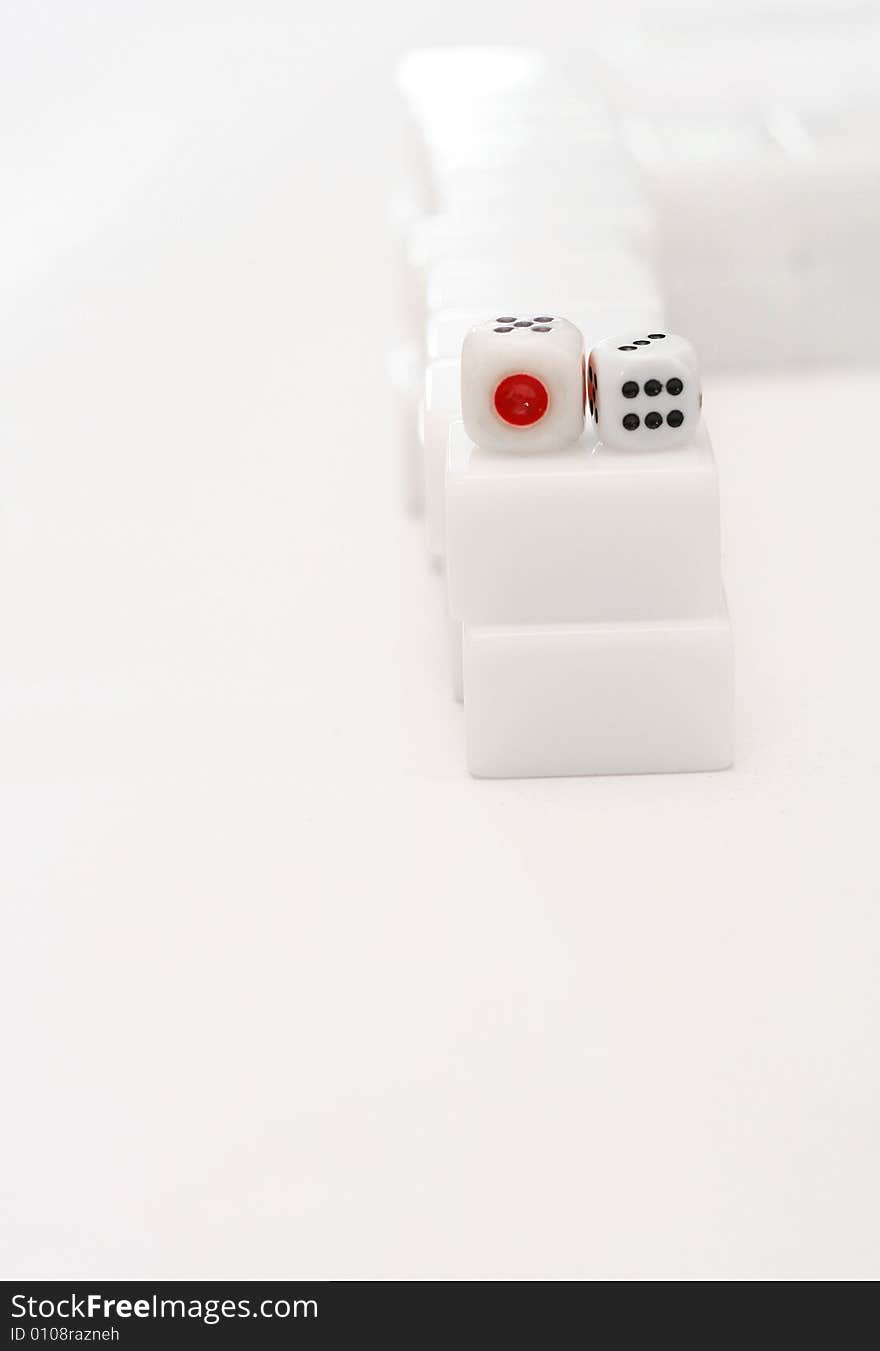 Two dice resting on top of mahjong tiles. Two dice resting on top of mahjong tiles.