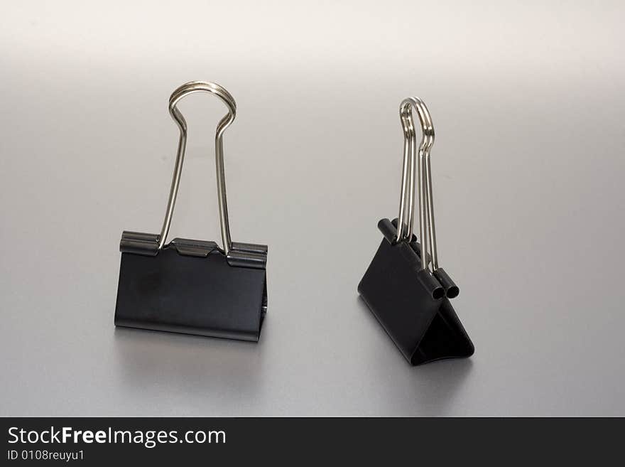 Two paper clip on silver background