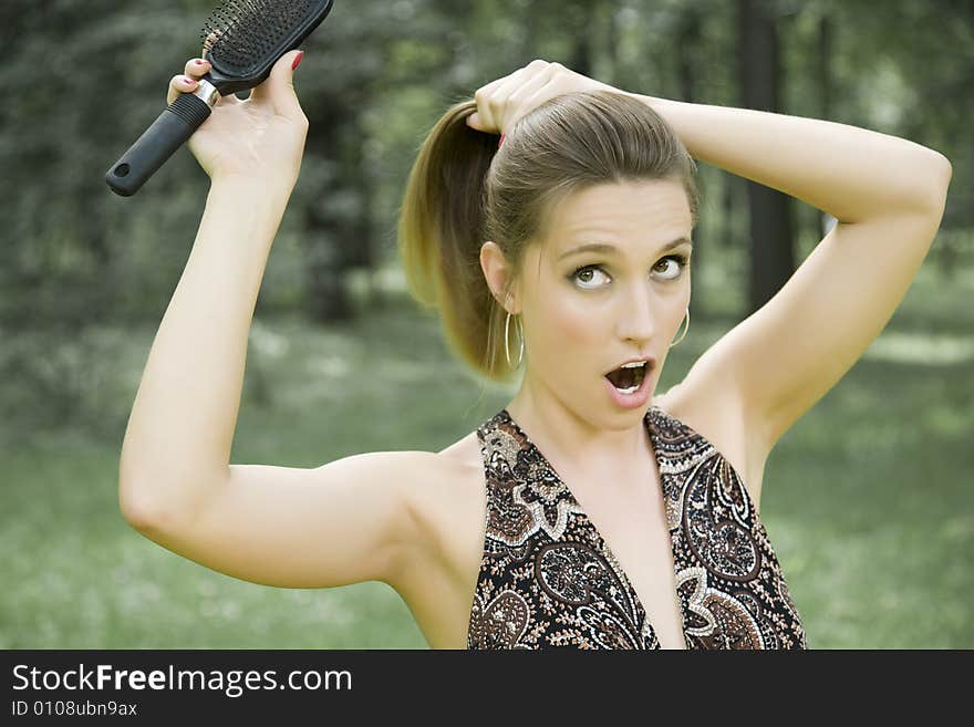 Young Woman With Comb Outdoors. Young Woman With Comb Outdoors