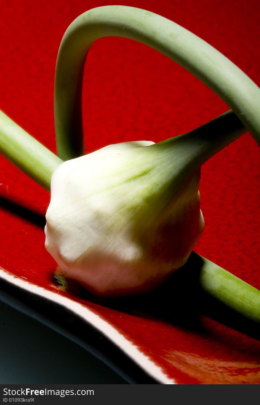 Fresh garlic on red plate. Fresh garlic on red plate