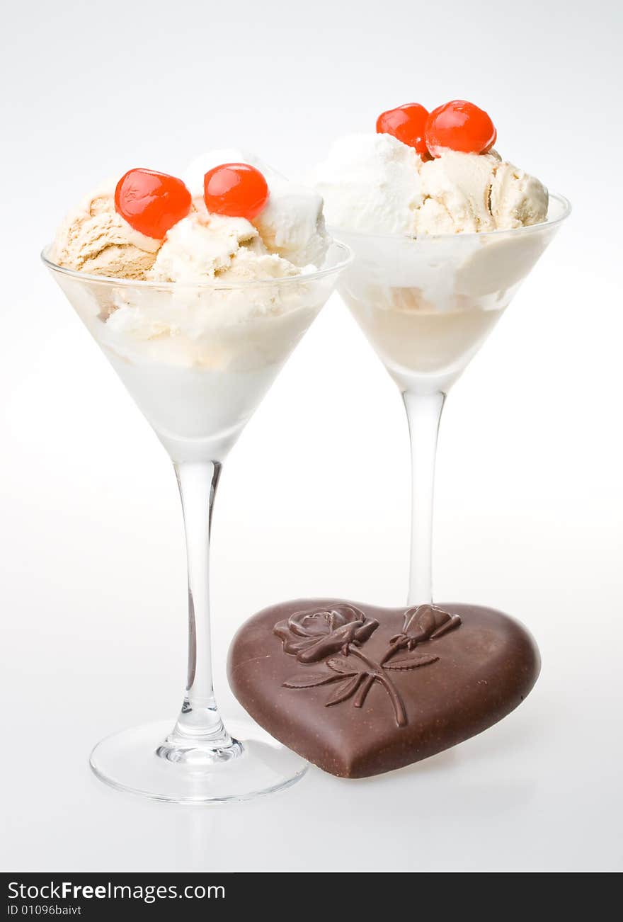 Ice-cream with a cherry in a glass on a white background. Ice-cream with a cherry in a glass on a white background.