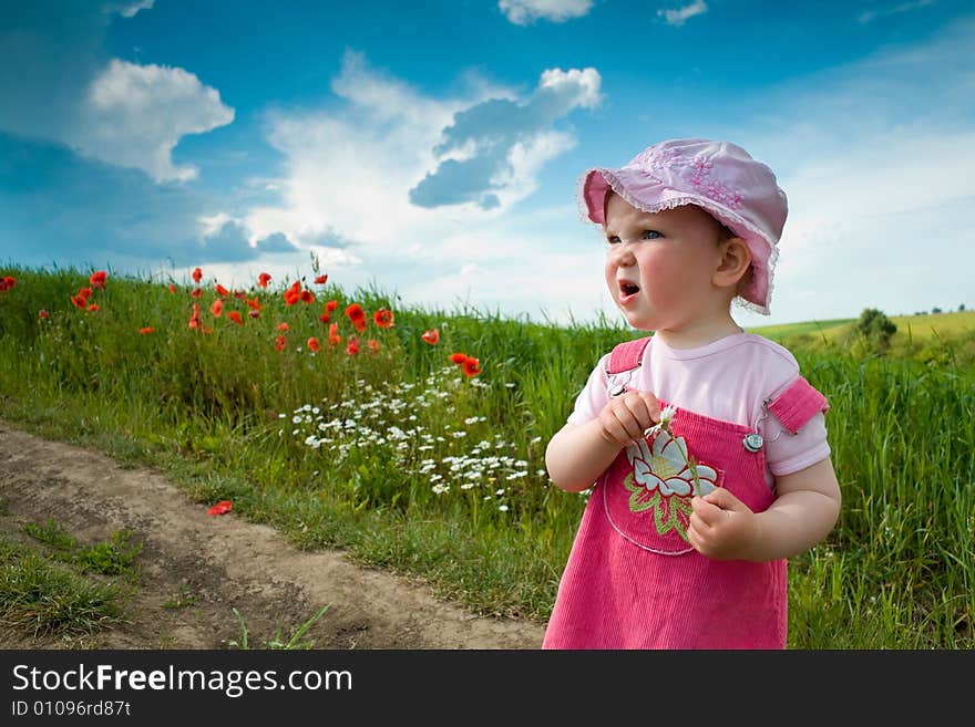 Baby-girl on a lane amongst a field