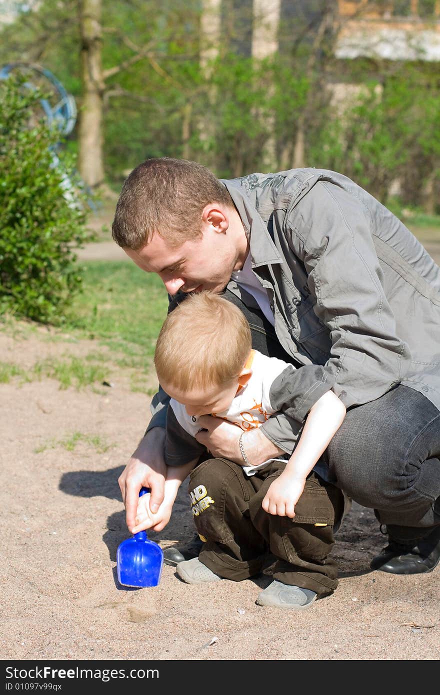 Child and father play, sand-box