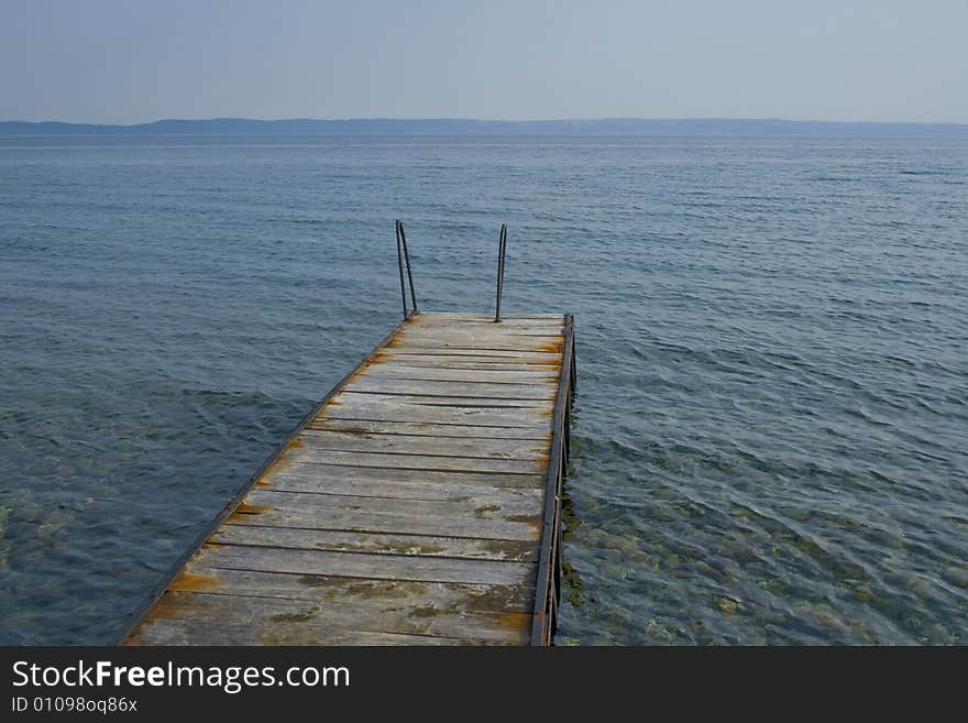 Old rusty wharf in the calm sea. Old rusty wharf in the calm sea