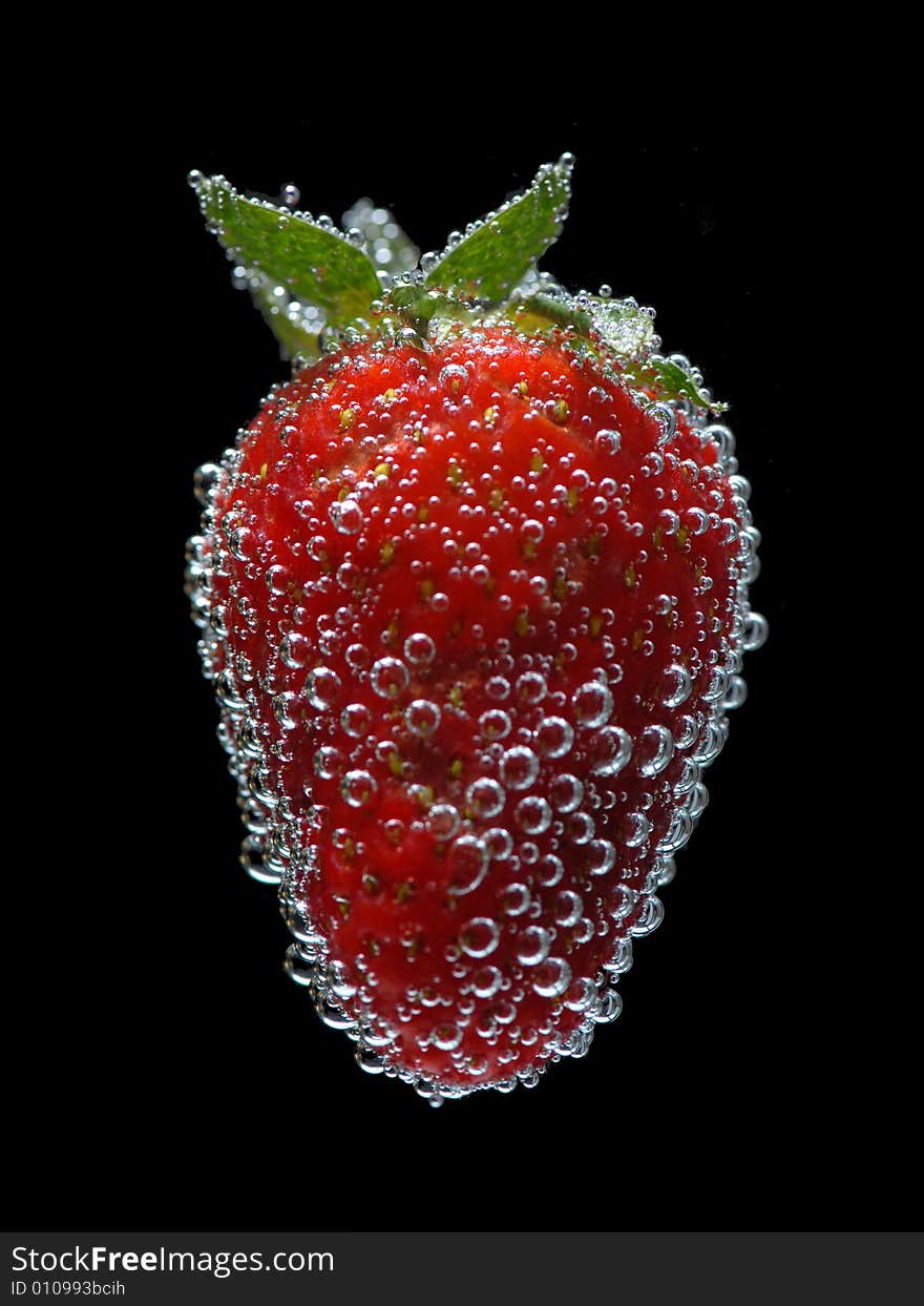 Strawberry in water on black background