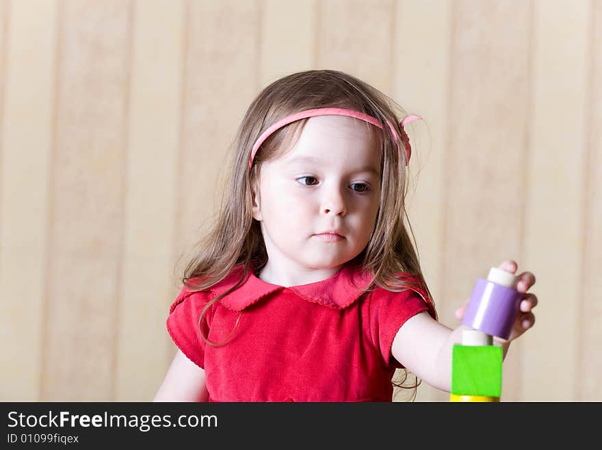 Portrait of a little girl building toy tower