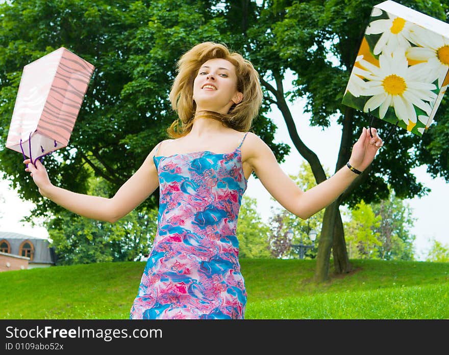 Girl jumps with bags on a background of the nature. Girl jumps with bags on a background of the nature