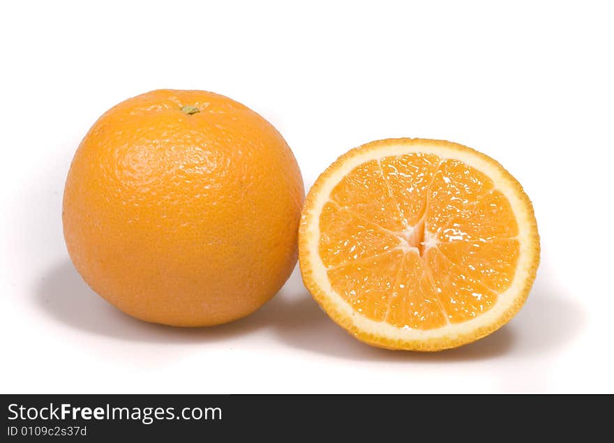 One full orange and a half on white ground. One full orange and a half on white ground