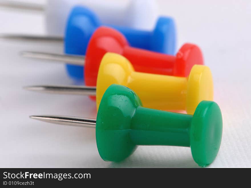 Macro image multicoloured push-pins jn white background